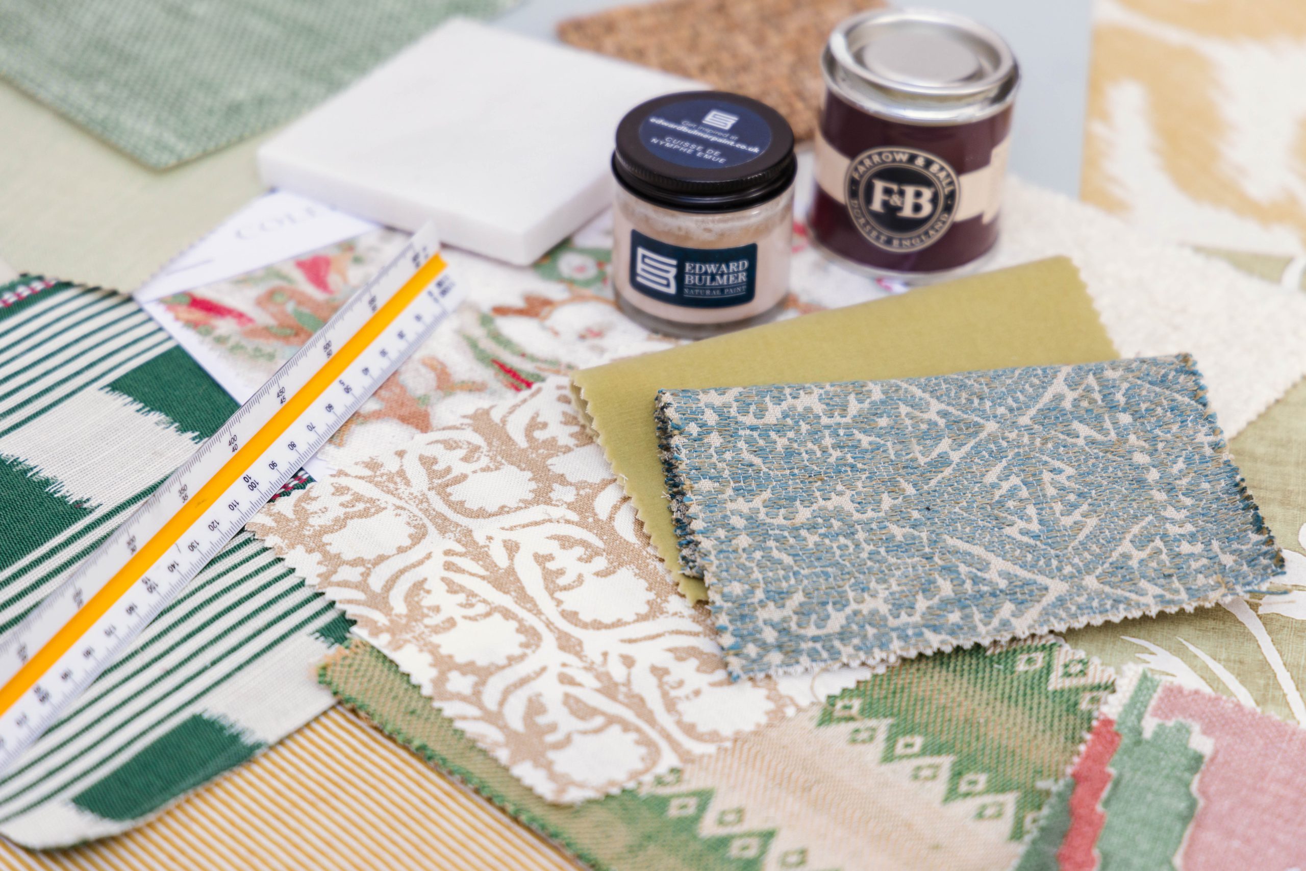 image showing fabric samples, floor tiles, tester paint pots and scale ruler for interior designer